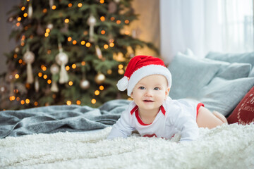 Obraz na płótnie Canvas Portrait of a cheerful baby boy in Santa hat
