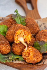 Rice balls stuffed with mozzarella cheese and deep fried. Italian dish - supplì al telefono, close up.