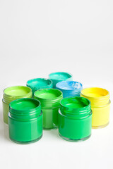 green, yellow and blue paints on white background