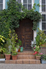 Fototapeta na wymiar Green Door Of Fairytale Cottage With small garden. Europe