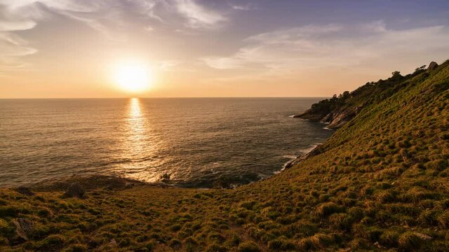 beautiful sunset on green grass coastline 4k time lapse, laem krating viewpoint at Phuket Thailand 