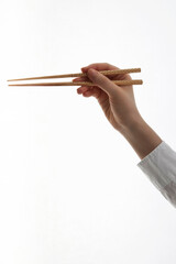 woman's hand holding chopsticks on white background