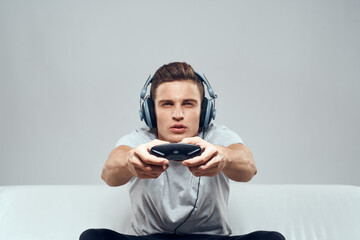 A man in headphones sits on the couch mobile game console hobby entertainment © SHOTPRIME STUDIO