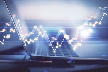 Forex graph hologram on table with computer background. Multi exposure. Concept of financial markets.