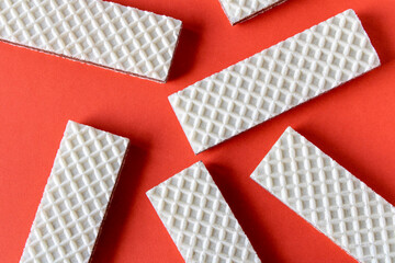Obraz premium Several waffles with chocolate on a red background.