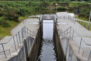 Modern Deep Concrete Lock Chamber & Metal Handrails on Industrial Canal