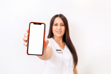A blurred woman in a white coat with a badge, shows a close-up of smarfton. Mock up. The concept of advertising and business