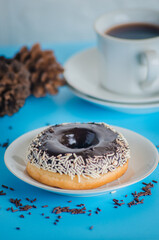 Black round donut at bright blue background
