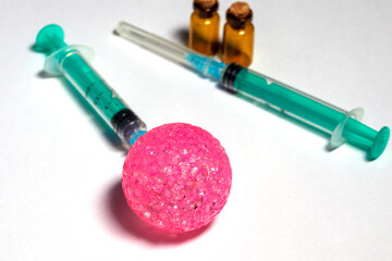 Pink ball with selective soft focus and blurred syringes and vials.  The concept of vaccinations,...