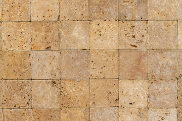 Wall background with Yellow natural sandstone tiles stitched together with clay