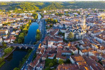 Scenic summer landscape of Perigueux with medieval Catholic Cathedral on bank of Isle river at sunset, France