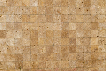 Wall background with Yellow natural sandstone tiles stiched together with clay
