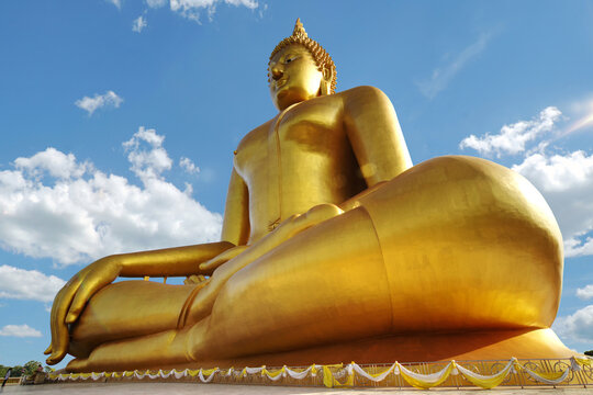 Golden Buddha Statue is Buddhism symbolic for Buddhist people to worship. Big Buddha statue in a sunny day with blue sky background. Buddhism concept.