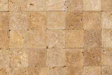 Wall background with Yellow natural sandstone tiles stitched together with clay