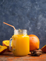 Natural homemade pumpkin juice in a jar on the table with ingredients copy space