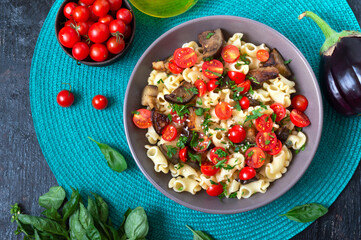 Pasta creste with grilled eggplant, cherry tomatoes and herbs. Delicious warm salad.