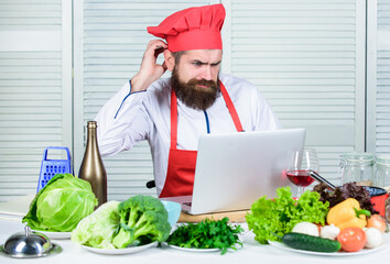 Elearning concept. Man chef searching internet recipe cooking food. Chef laptop read culinary...