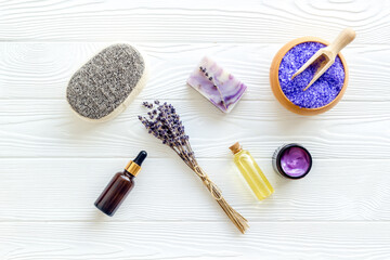 Fototapeta na wymiar Lavender spa set. Violet bath salt, soap, essence oil on white wooden background