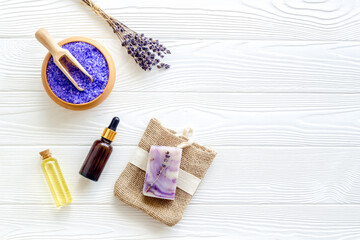 Lavender spa set. Violet bath salt, soap, essence oil on white wooden background