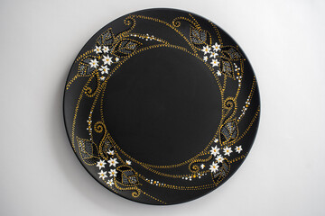 Decorative ceramic plate with white, golden and silver colors, painted plate on white background, dot painting