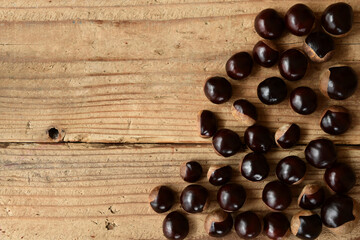 Chestnuts isolated on wooden background.