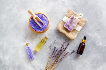 Lavender spa set. Violet bath salt, essence oil on grey stone background