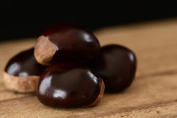 Chestnuts isolated on wooden background.