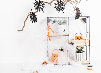 Halloween interior decoration with bats, spider web, skull over white wall. Greeting card, holiday decoration concept. Copy space