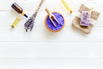 Fototapeta na wymiar Lavender spa set. Violet bath salt, soap, essence oil on white wooden background