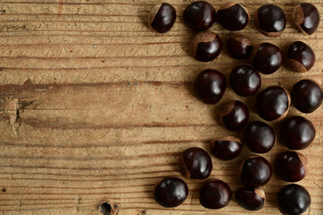 Chestnuts isolated on wooden background.