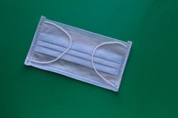 Medical mask on a green background. Respiratory protection.
