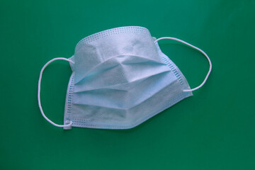 Medical mask on a green background. Respiratory protection.