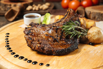 Cowboy beef steak on a wooden board with potatoes
