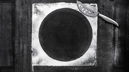Flour and steel pizza cutter  on old  shabby baking sheet. Baking background