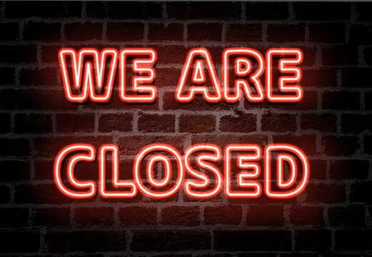 We are closed  red neon light entrance sign on brick wall