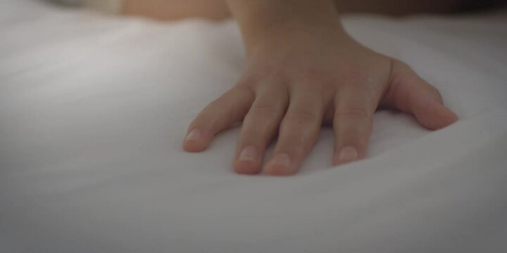 Female Hand set up white bed sheet in room. bedtime concept. Red camera. Morning relax time