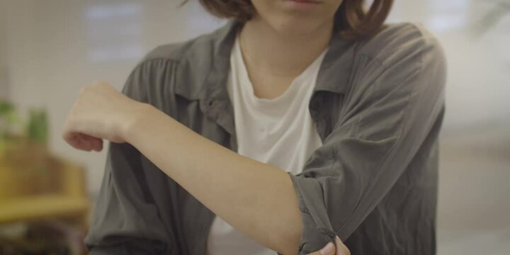 Woman Rolling Up A Sleeve And Hearing Something. Hearing Something And Leaving. Girl Roll Up One's Sleeves  At Home. Woman Wearing Shirt.