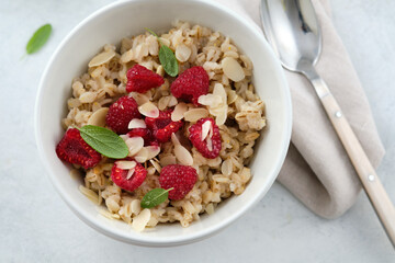 Oatmeal with raspberries, honey, almond petals. Healthy breakfast.