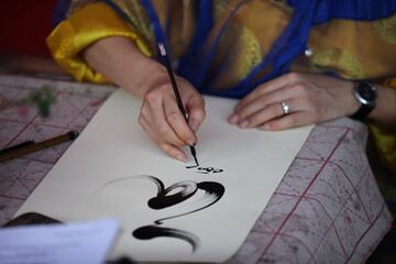 Hanoi, Vietnam -  Calligrapher writing words on paper. Calligraphy is old culture of Vietnam