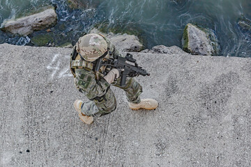 Army soldier in Combat Uniforms with assault rifle. Military equipment, army helmet and military...