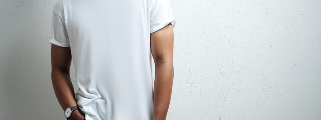 asian man in white blank t-shirt, grunge wall, studio close-up, casual style. Wide screen, panoramic