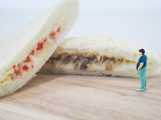 Miniature people, Fat man looks at tuna mayonnaise and crab sticks mayonnaise on white background