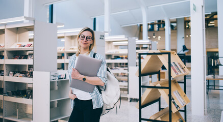 Confident female student in contemporary library