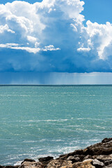 Cumulus Clouds and Torrential Rain on the Horizon over the Mediterranean Sea in front of the ancient village of Tellaro, Gulf of La Spezia, Liguria, Italy, Europe