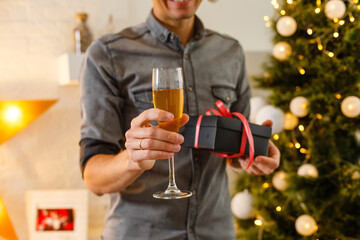 Happy mid adult man near Christmas tree at home