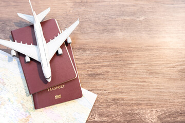 Passport with a map on old wooden background.Travel planning.Top view of traveler accessories with a plane on world map.Preparation for travel.Traveling Journey Vacation Holiday concept.