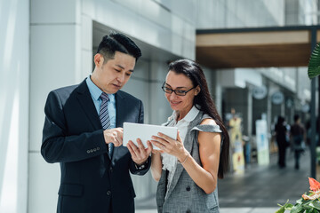 Two confident business people using a digital tablet together stock photo