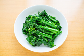 A dish of Chinese vegetable stir-fried Chinese kale and cabbage heart on a wooden table