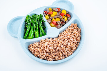 Nutritional meal for children on a plate on white background