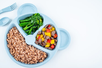 Nutritional meal for children on a plate on white background